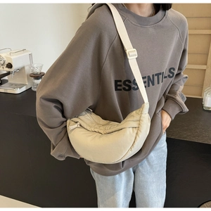 Detail shot of the beige crescent crossbody bag showing its durable nylon fabric and wide strap