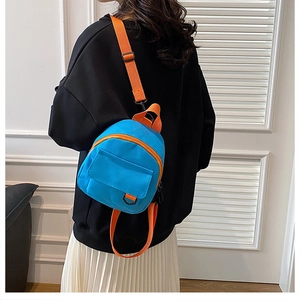 Détail d'un mini sac à dos en toile bleu et orange avec bandoulière réglable