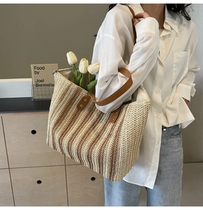 Détail du grand sac cabas en paille tressée avec bandoulière en cuir marron et rayures