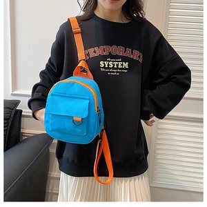 Détails du mini sac à dos en toile bleue avec des accents de sangles orange vif