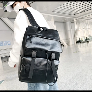 Close-up of a black PU leather backpack showing large capacity and buckle closure details