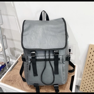 Vue détaillée d'un sac à dos en similicuir gris avec boucle à rabat et fermeture cordon