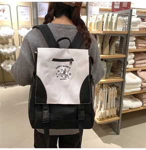 Detail of contrast nylon backpack featuring cartoon UFO illustration and buckle closure