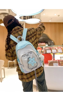 Detail of fashion nylon backpack featuring pastel patchwork colors and star charm accessory