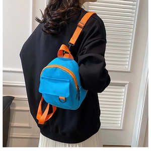 Vue détaillée d'un mini sac à dos en toile avec tissu bleu et bretelles orange éclatantes