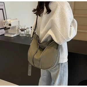 Detailed back view of an olive green nylon crescent bag with adjustable straps and zippers