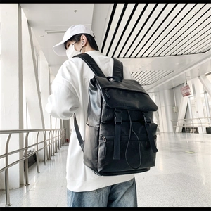 Detail of a black PU leather fashion backpack with buckle flap and side pockets