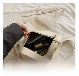 Detail view of the spacious cream PU shoulder bag interior with daily essentials