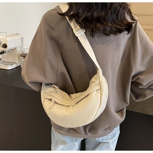Vista dettagliata della tracolla regolabile della borsa a mezzaluna in nylon beige