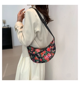 Model wearing a vintage floral half-moon crossbody bag with adjustable black strap