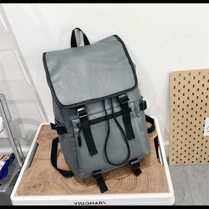 Sac à dos minimaliste en cuir PU gris avec boucles et poche avant sur plateau en bois
