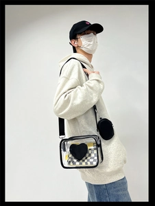Détail d'un sac bandoulière en PVC transparent avec bordure noire et cœur décoratif