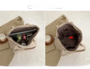 Detailed interior of a beige canvas tote bag showing main zipper and multi-functional pockets