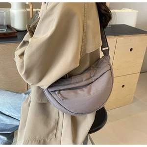 Detailed view of grey nylon crescent crossbody bag with adjustable wide shoulder strap