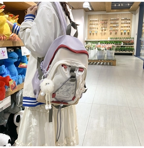 Close-up of lilac and cream nylon backpack featuring UFO print and cute star charm details