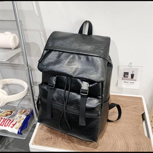 Minimalist black PU leather backpack with buckle straps and drawstring closure in studio set