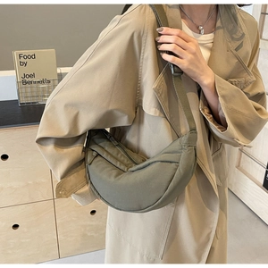 Detailed side view of military green crescent nylon crossbody bag with adjustable strap