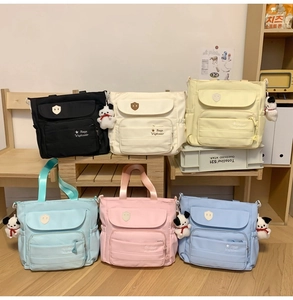 Dettaglio di borse tote alla moda in nylon multicolore con ciondoli a forma di cane
