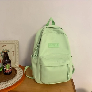 Sac à dos en nylon vert menthe avec poche frontale zippée et logo de marque sur le devant