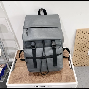 Minimalist grey PU leather backpack with buckle flap and textured finish for men and women