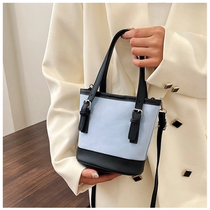 Close-up of light blue and black contrast bucket bag with silver metal buckles