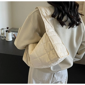 Lifestyle shot of large cream quilted shoulder bag showing the soft texture and trendy design
