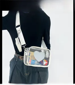 Détail du sac bandoulière en PVC transparent avec écusson coeur bleu et large sangle