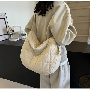 Detail of large quilted shoulder bag showing the classic diamond pattern and wide strap