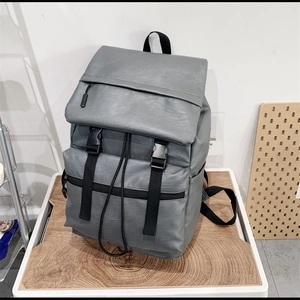 Detail view of the gray PU leather backpack featuring a top flap with dual plastic buckles