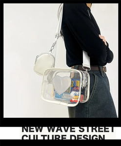 Détail d'un sac bandoulière en PVC transparent avec applique cœur blanc et petite pochette