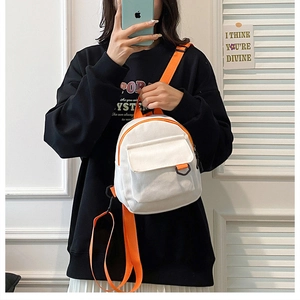 Détail d'un mini sac à dos en toile avec sangles orange vif et boucle anneau en D
