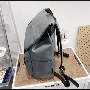 Side view of dark gray PU leather backpack showing main compartment and side pocket