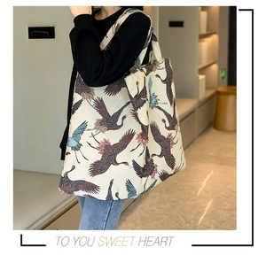 Detailed view of canvas tote bag with vintage crane embroidery and floral pattern print