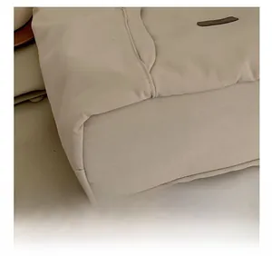 Detailed close-up showing precision stitching on the beige canvas shoulder bag bottom