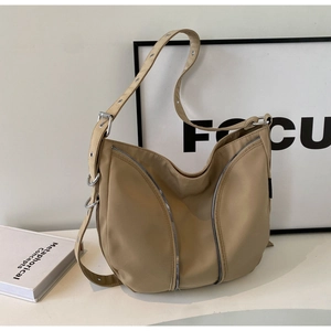 Minimalist khaki nylon hobo bag with decorative vertical zippers and wide metal eyelet strap