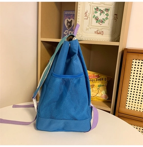 Detail view of the durable nylon backpack with mesh side pocket and adjustable purple strap
