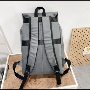 Detail view of the gray PU leather backpack showing adjustable black webbing straps