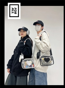 Détail de sacs bandoulière en PVC transparent avec écussons cœur et larges bandoulières