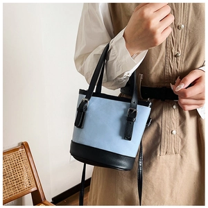 Close-up of light blue and black bucket bag featuring textured PU fabric and metal buckle