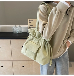 Detailansicht der hellgrünen Cord-Textur und Kordelzugverschluss an einer Shopper-Tasche