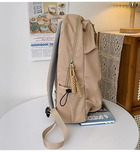 Detail of breathable honeycomb mesh back and wide adjustable straps on a beige nylon backpack