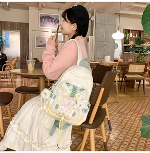 Detail of trendy nylon backpack with pastel color-block design and star pendant