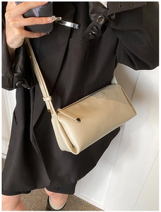 Close-up of beige PU leather shoulder bag with ELUKADI logo worn over a black blazer