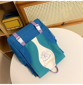 Detail of multi-color nylon backpack featuring UFO print and secure buckle closure