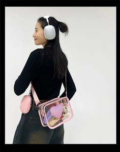 Détail du sac à épaule en PVC transparent avec bordure rose et écusson cœur violet