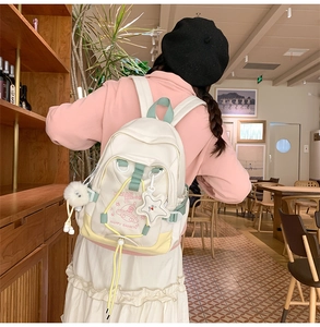 Close-up of stylish nylon backpack featuring cartoon UFO prints and star charm pendant