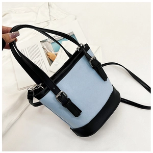 Detail of light blue and black PU leather bucket bag with silver metal buckle