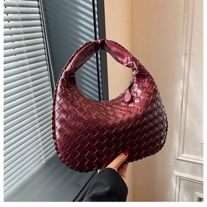 Detailed view of the woven deep red PU leather texture on the hobo handbag surface