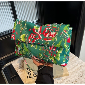 Green floral canvas crossbody bag with silver chain strap and large flap design