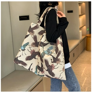 Close-up of crane print canvas tote bag with wide straps and oriental aesthetic design
